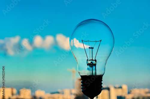 The incandescence bulb by the industrial city background