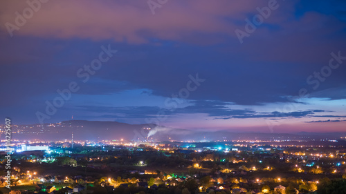 The beautiful night view on the city against the background of cloud stream. Wide angle