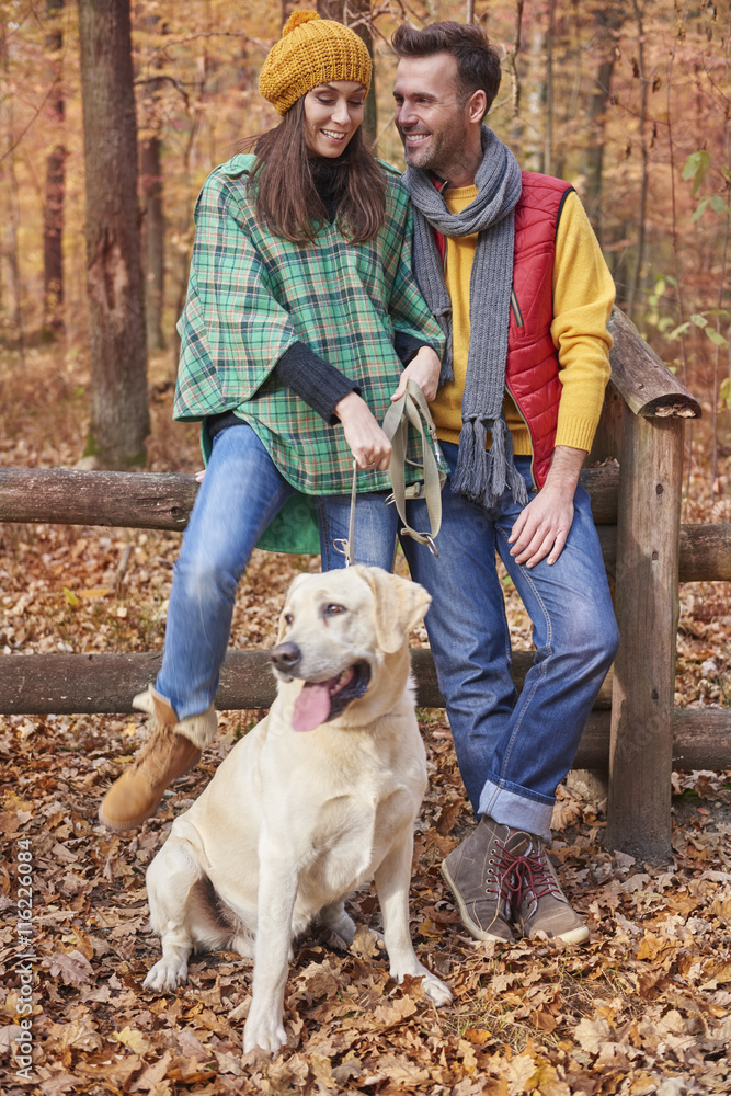 Couple spending time with dog in forest Couple spending time with dog in forest
