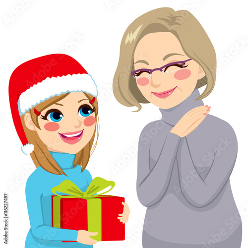 Happy granddaughter in Christmas day giving present to lovely grandmother