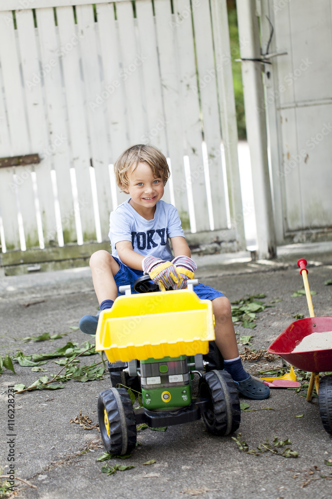Kleiner Junge auf seinem Spielzeug Traktor