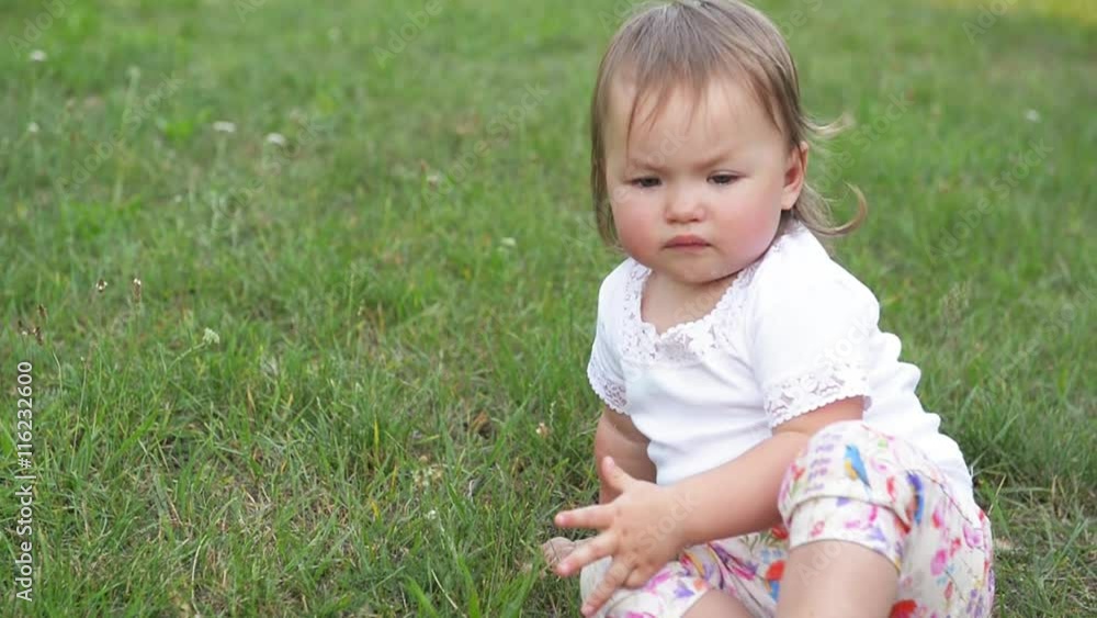 Crying little child in a park, cute girl sadly spending time outdoor on a warm summer day Crying little child in a park, cute girl sadly spending time outdoor on a warm summer day