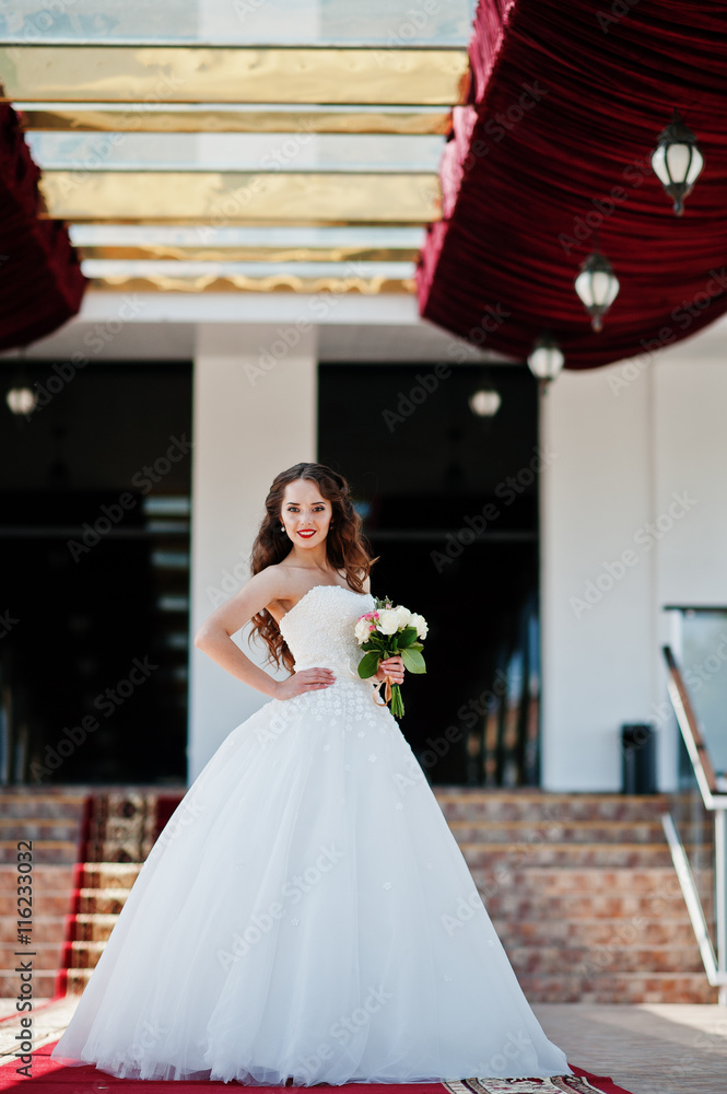 Portrait of beautiful sensual young bride at wedding hall on red