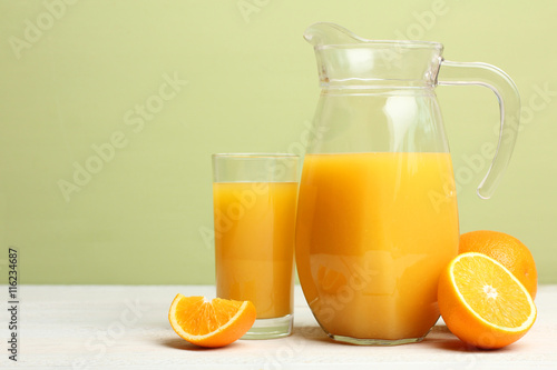 a carafe of orange juice on wooden  background