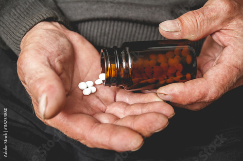 Obraz na plátne Many pills from a glass bottle in the Senior hands