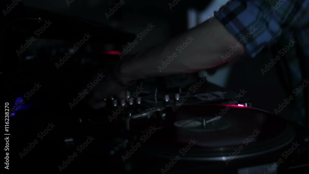 DJ scratching vinyl records and mixing on the Decks at a disco in Nightclub DJ scratching vinyl records and mixing on the Decks at a disco in Nightclub