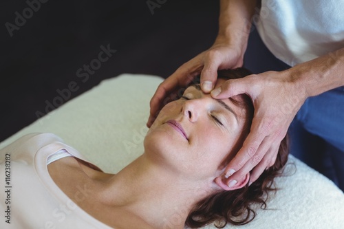 Woman receiving head massage from physiotherapist photo