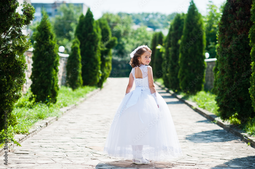 Portrait of cute little girl on white dress and wreath of first Portrait of cute little girl on white dress and wreath of first