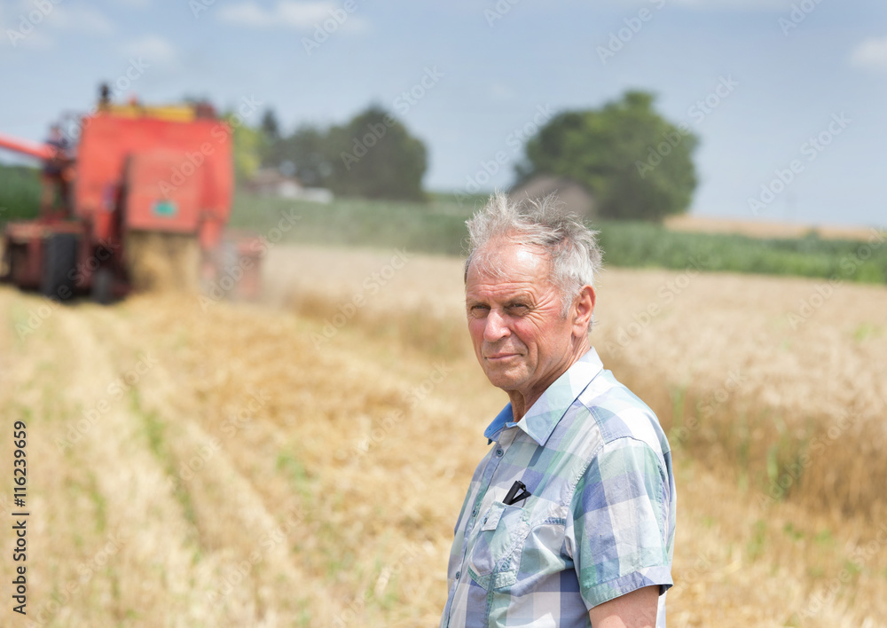 Farmer on field with combine harbester