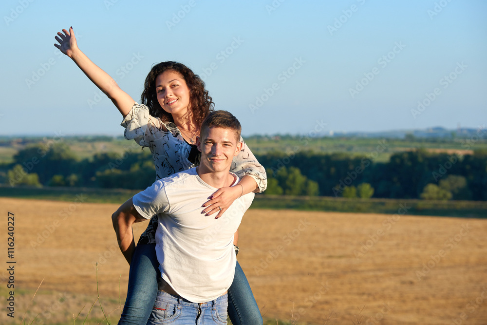happy couple having fun on outdoor, girl riding on man back and fly - romantic travel and people concept, summer landscape with wheaten field happy couple having fun on outdoor, girl riding on man back and fly - romantic travel and people concept, summer landscape with wheaten field