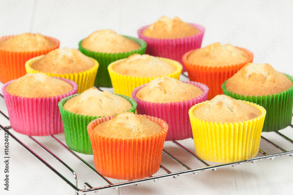 Homemade Colorful Plain Cupcakes On A Stand. White Table. Homemade Colorful Plain Cupcakes On A Stand. White Table.