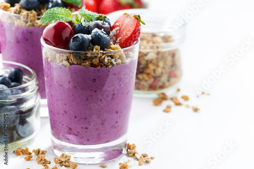 Blueberry dessert with granola on a white background, closeup