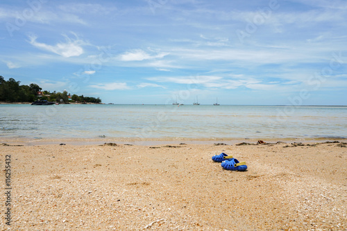 Children shoes on the beach © FootageLab