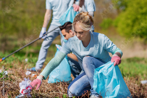 volunteers with garbage bags cleaning park area