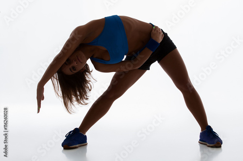 Sporty flexible girl doing stretching exercise