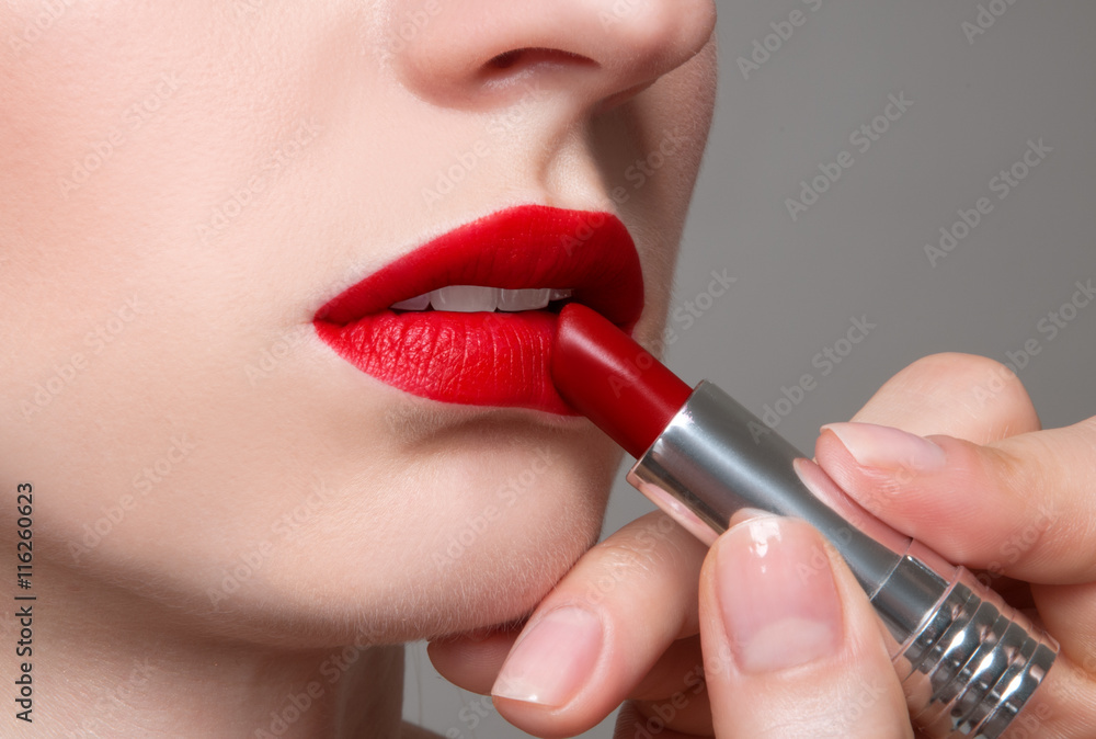 Beauty portrait applying red lipstick on lips perfect make up.