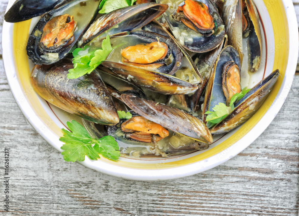 Mussel soup with fresh parsley on wooden table Mussel soup with fresh parsley on wooden table
