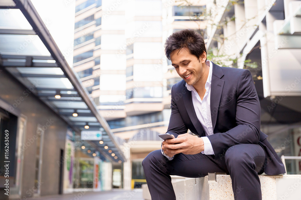 Portrait of confident businessman with mobile phone outdoors