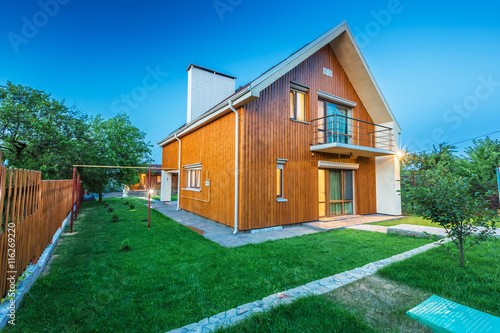 Wooden house with meadow in front of it