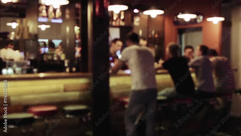 Group of people is sitting in a bar, Defocused background Group of people is sitting in a bar, Defocused background