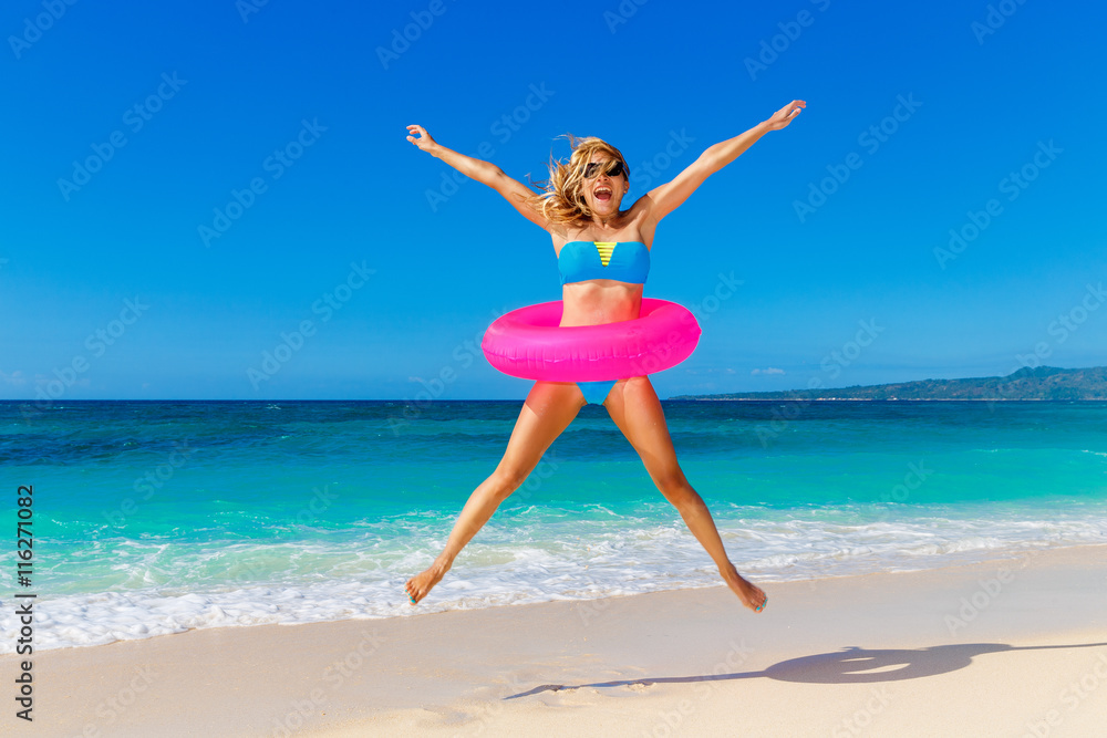 Young beautiful girl in blue bikini having fun on a tropical bea Young beautiful girl in blue bikini having fun on a tropical bea