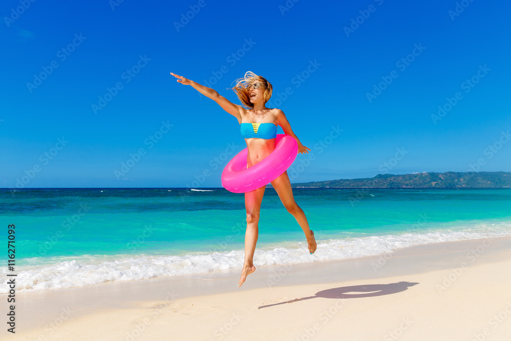 Young beautiful girl in blue bikini having fun on a tropical bea