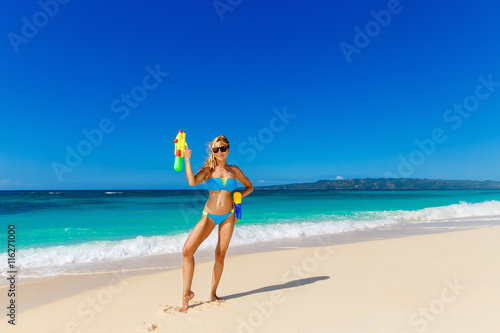 Young beautiful girl in blue bikini having fun on a tropical bea