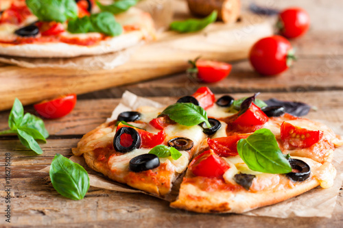 pizza with tomatoes, mozzarella and basil photo