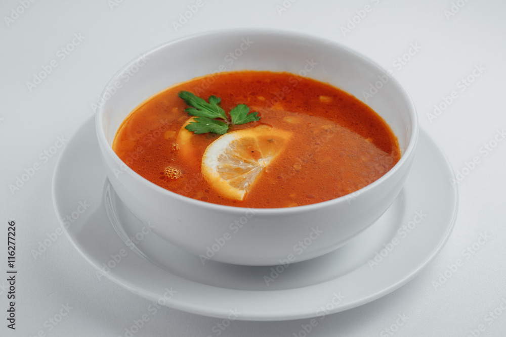 Solyanka with lemon and parsley in a white plate Solyanka with lemon and parsley in a white plate