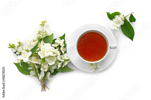 Cup of tea with jasmine flowers on white background