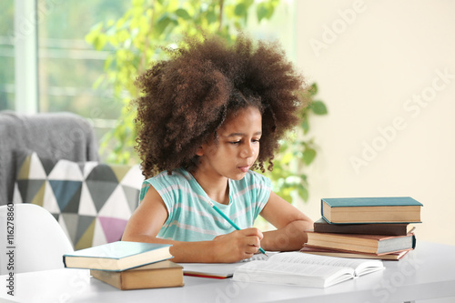 Cute African girl doing hom...