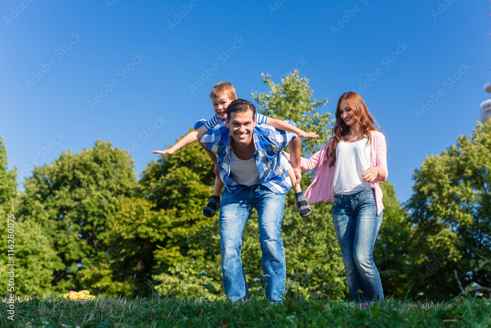 Daddy carrying son piggyback on his back Daddy carrying son piggyback on his back