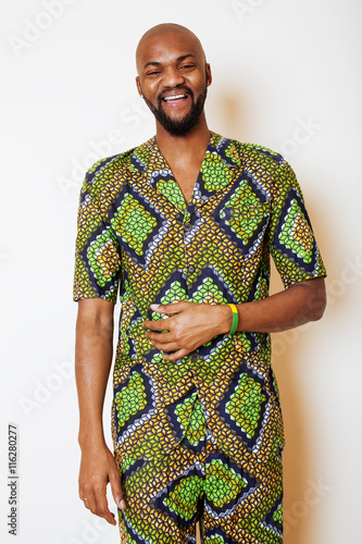 portrait of young handsome african man wearing bright green national costume smiling gesturing photo