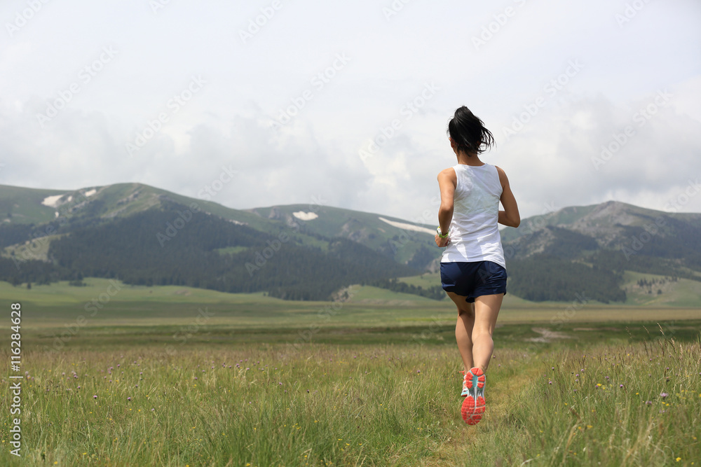Obraz premium healthy young woman trail runner running on beautiful trail