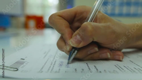 View of Woman's Hand Neatly Complete a Form Print. Woman Writes With a Pen. Closeup photo