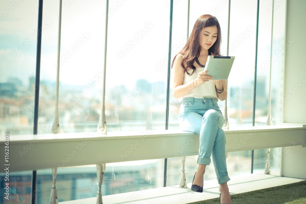 Portrait of a casual young businesswoman using tablet