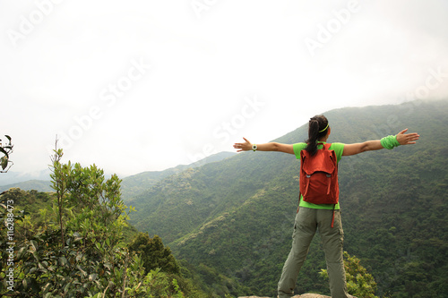 cheering young woman hiker open arms outdoor