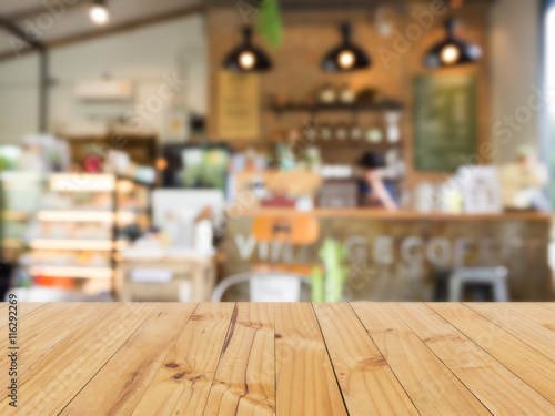 Wooden table with blurred coffee shop background