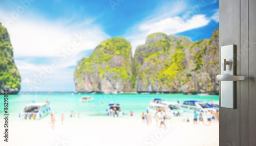 opened wooden door to beautiful beach with tourist at maya bay  phi phi leh island  thailand