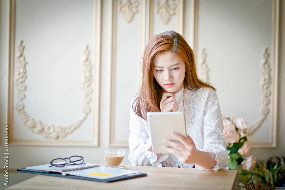 Woman with laptop watching sad movie on tablet Woman with laptop watching sad movie on tablet