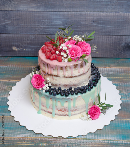 wedding color drip cake with roses, blueberries and  raspberries