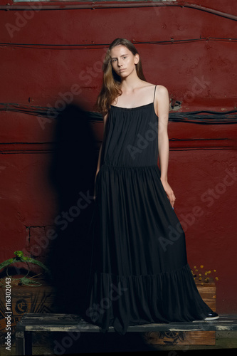 fashion model in long designers black dress in night show