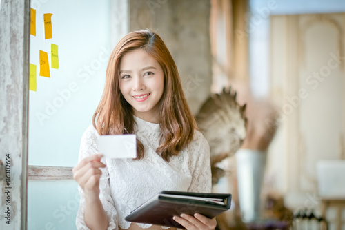 Beautiful businesswoman with smile,showing blank name card