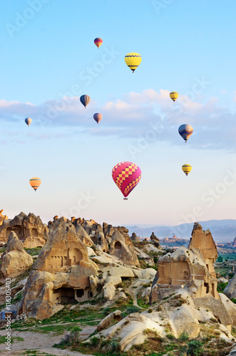 Hot air balloons over mountain landscape in Cappadocia