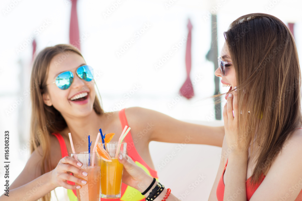 two attractive young women drinking cocktails two attractive young women drinking cocktails