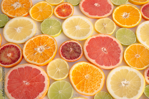 Slices of orange, grapefruit, blood orange lemon, lime arranged as a background