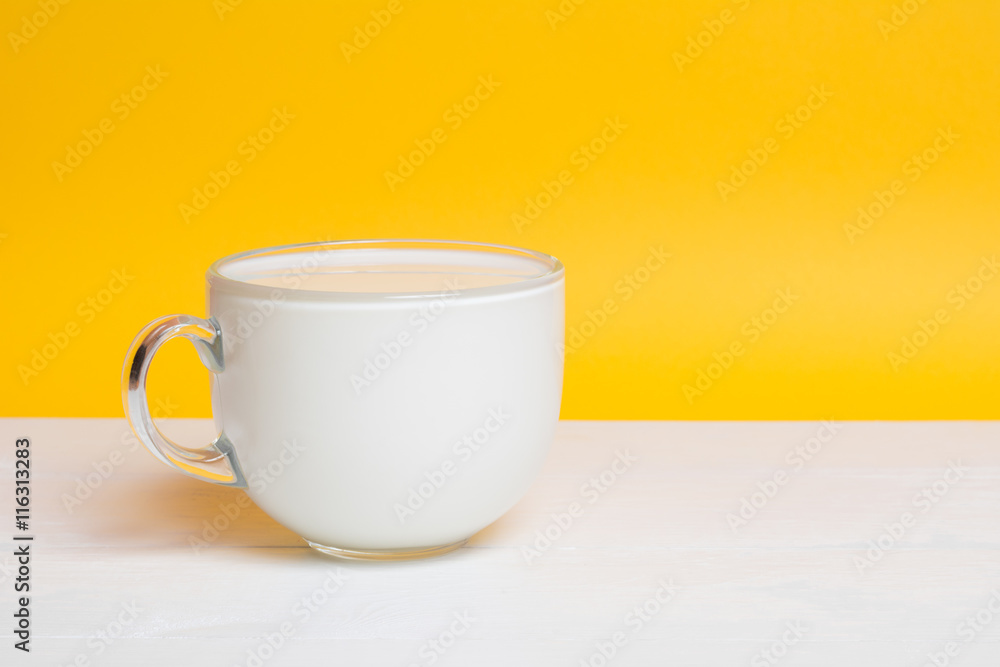 Glass cup full of milk on white wooden table Glass cup full of milk on white wooden table