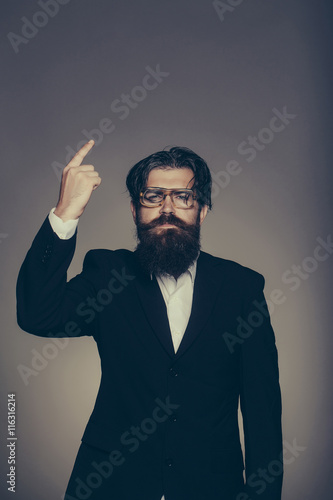 Handsome man points forefinger upwards