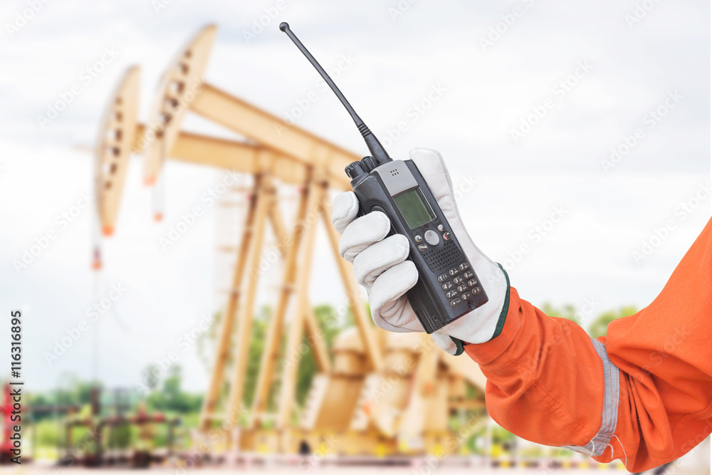 walkie-talkie radio in hand crude oil pump background. comunication in oil  and gas process foto de Stock | Adobe Stock