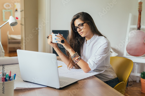 Vision of success..young woman working on a computer in her home office